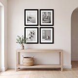 Entryway with four black Galleria frames hung as a two-by-two square above an oak console table