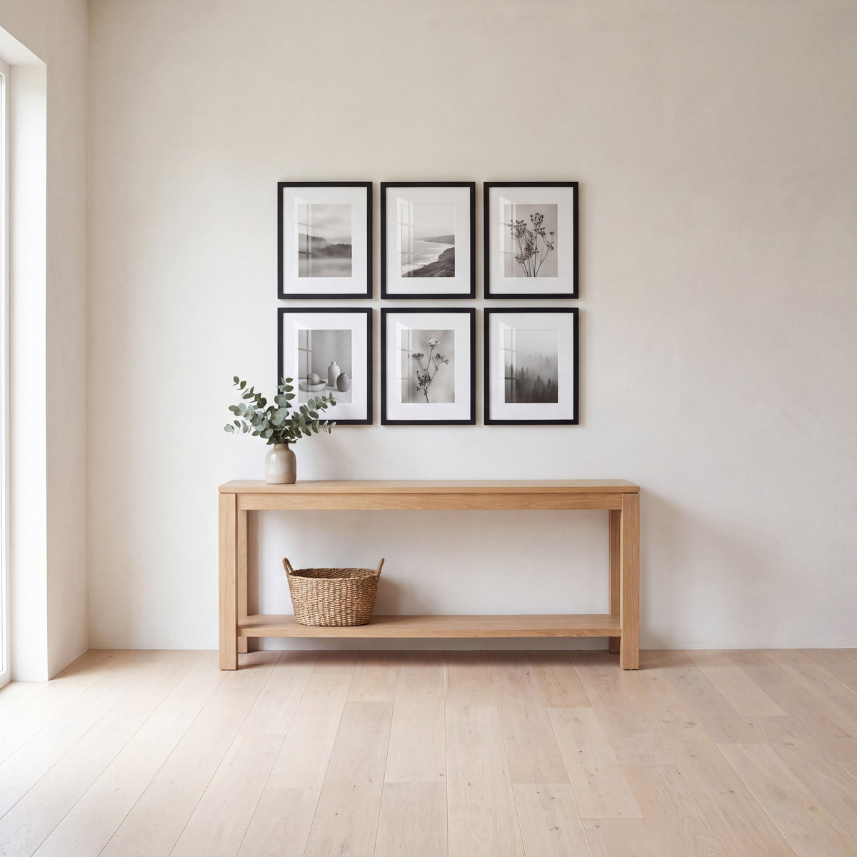 Entryway with six black Galleria frames hung three across and two down above an oak console table