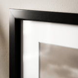 Close-up of the mitred corner, black moulding and bevelled white mat edge 
