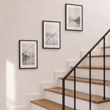 Three matching glazed black 12x18 Brooklyn frames stepping evenly up a staircase wall