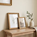 Matted 8x10 and full-bleed 5x7 gold Heirloom frames styled on the console 