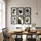 Six black 12x17 unmatted poster frames in a two-by-three grid above a dining table 