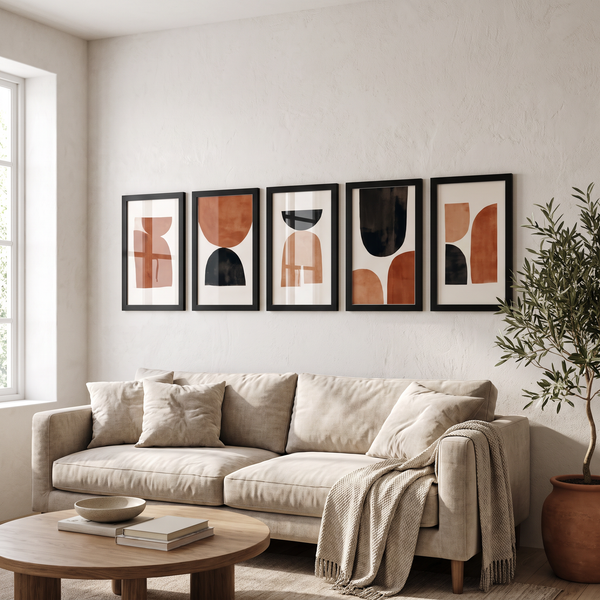 Five black 12x17 unmatted poster frames in a row above a linen sofa #flat