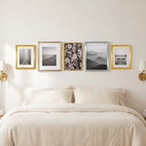 The row above a bed with cream linen bedding 