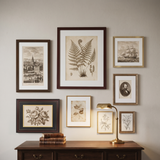 The eight-frame set above a walnut writing desk in a traditional study 