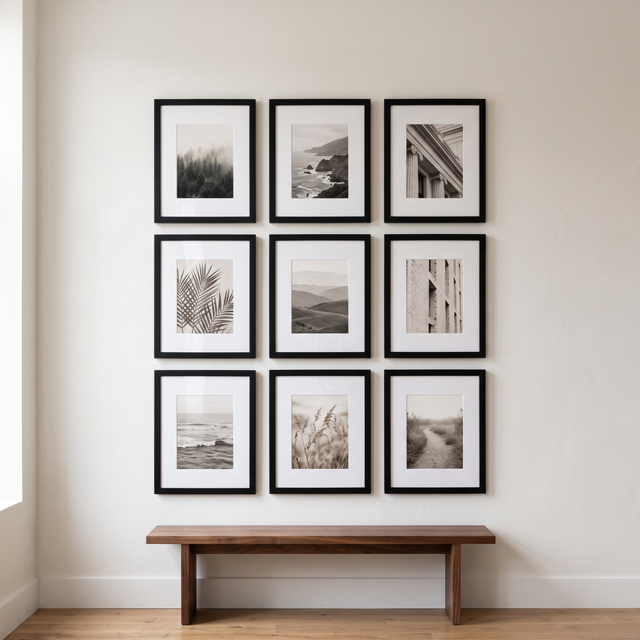 Black Wide Mat Grid Nine: nine black Signature 11x14 frames with wide 5x7 mats, hung as a three-by-three grid. Shown in a living room, above a low walnut bench 