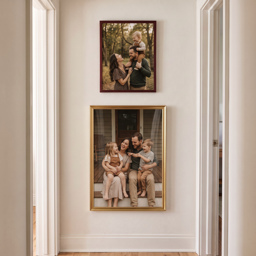 Brass & Mahogany Ladder: a mahogany 8.5x11 hung above a brass 13x19, both unmatted: a narrow vertical pair. Shown in a hallway, on the narrow stretch of wall beside a doorway, with family photos in the frames 