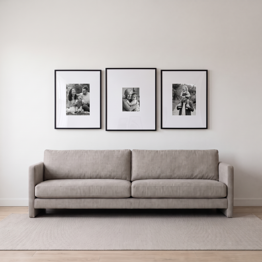 Wide Mat Statement Trio: a black Streamline 24x30 (9x12 mat) between two 22x28s (12x16 mats), in one row. Shown in a modern living room, above a long neutral linen sofa, with family photos in the frames 