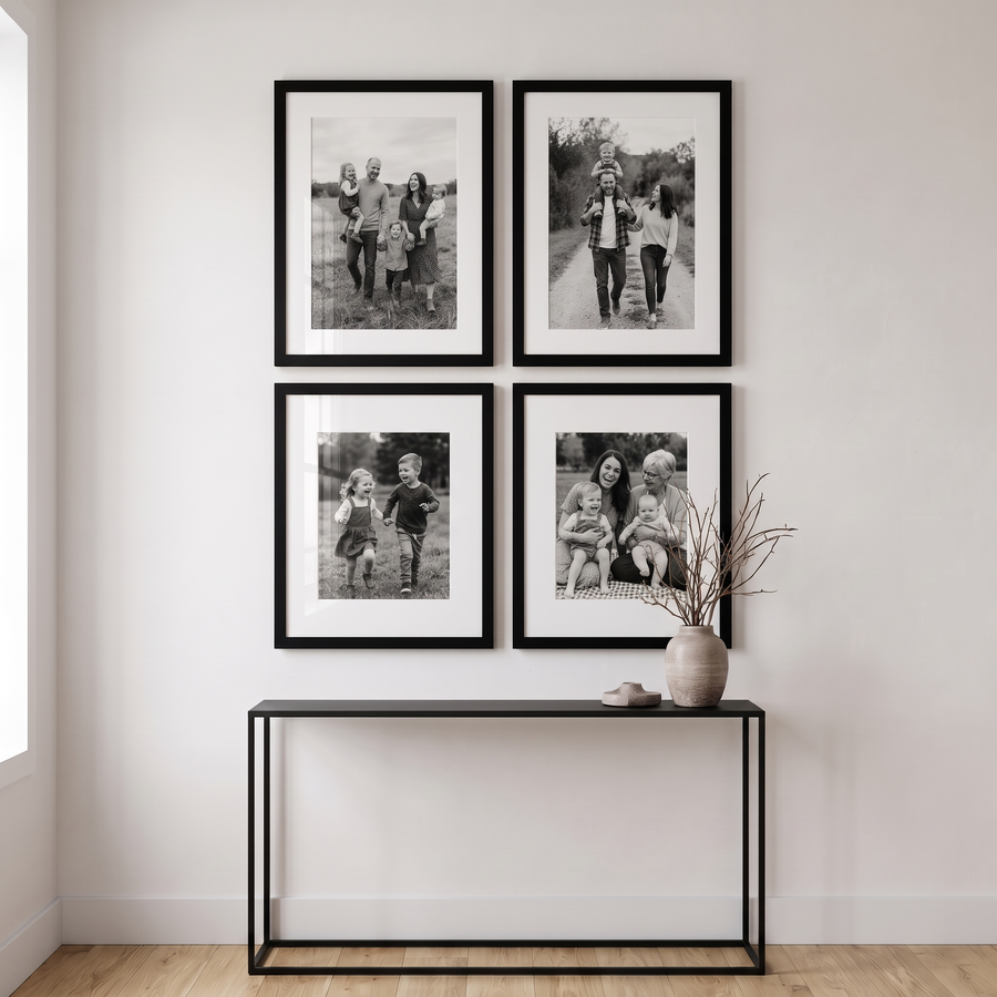 Epic Matted Statement Four: four black Epic frames in a two-by-two block: two 16x22 (12x18 mat) over two 16x20 (11x14 mat). Shown in a living room with a tall wall, above a slim black console table, with family photos in the frames 