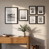 The six-frame set above an oak console in a sunlit entry hall 