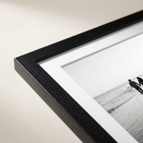 Corner detail of the black woodgrain Hudson moulding and white mat 