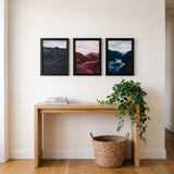 The poster trio above an oak console table 
