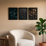 The poster trio above a boucle reading chair in warm afternoon light 